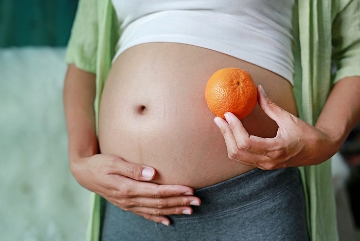 Беременная с мандарином